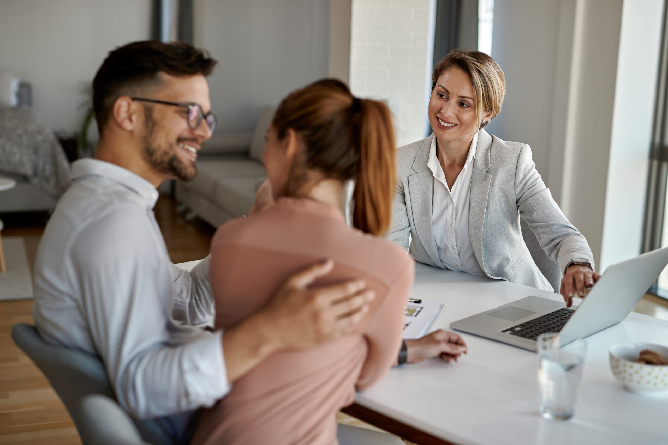Rear estate agent having meeting with a couple in the office.